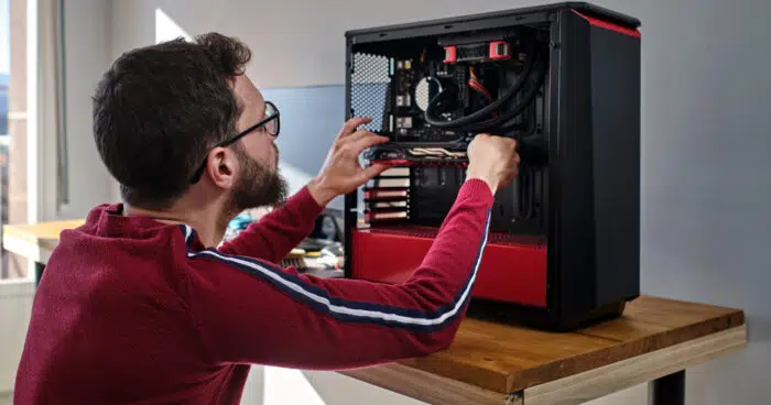 young man installing graphics card to his desktop computer